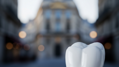Close-up of a pristine, white ceramic dental implant crown on a metallic post, representing a perfect tooth restoration. The background is an extremely blurred, elegant Parisian architectural street scene with soft light, hinting at the location.