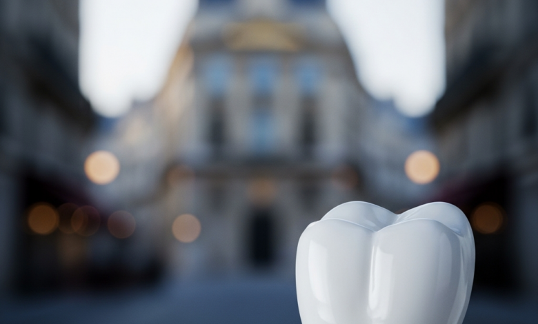 Close-up of a pristine, white ceramic dental implant crown on a metallic post, representing a perfect tooth restoration. The background is an extremely blurred, elegant Parisian architectural street scene with soft light, hinting at the location.