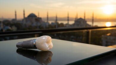Un modèle d'implant dentaire parfait posé sur une table en verre, avec en arrière-plan une vue panoramique floue et ensoleillée de la skyline d'Istanbul, représentant le tourisme dentaire en Turquie.