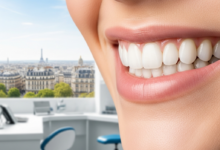 A close-up, photorealistic image of a beautiful, healthy human smile with perfectly contoured gums and white teeth. The background is softly blurred, showing hints of a clean, modern dental clinic and a distant, indistinct Parisian cityscape.