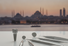 Image photoréaliste d'une clinique dentaire moderne et immaculée, avec un implant dentaire ou des instruments stériles en premier plan, et une vue floue du paysage urbain d'Istanbul à l'arrière-plan.