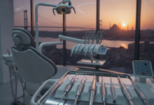 Image montrant un intérieur de clinique dentaire moderne et high-tech en gros plan, avec des instruments dentaires stériles au premier plan. En arrière-plan, une vue floue et panoramique du coucher de soleil sur la ville d'Istanbul avec des monuments emblématiques.